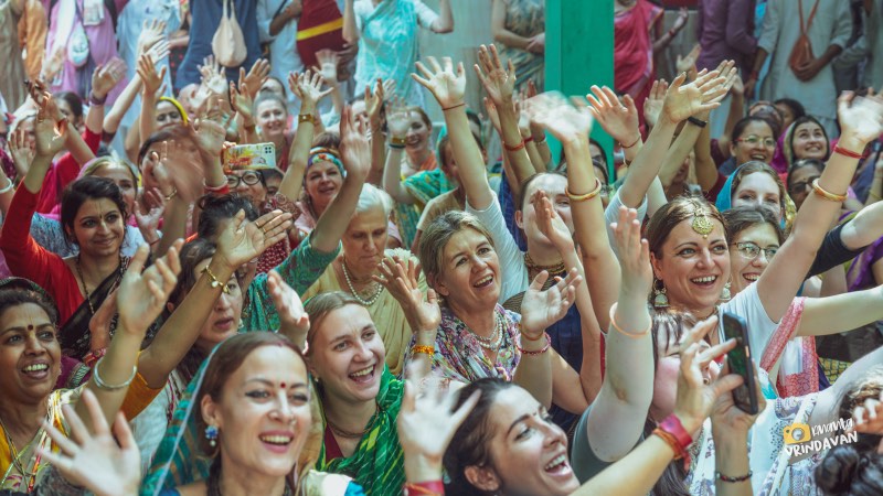 A crowd of devotees dancing with raised arms