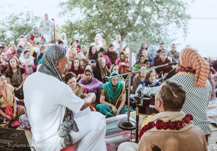 Devotees seated for a class beneath the trees